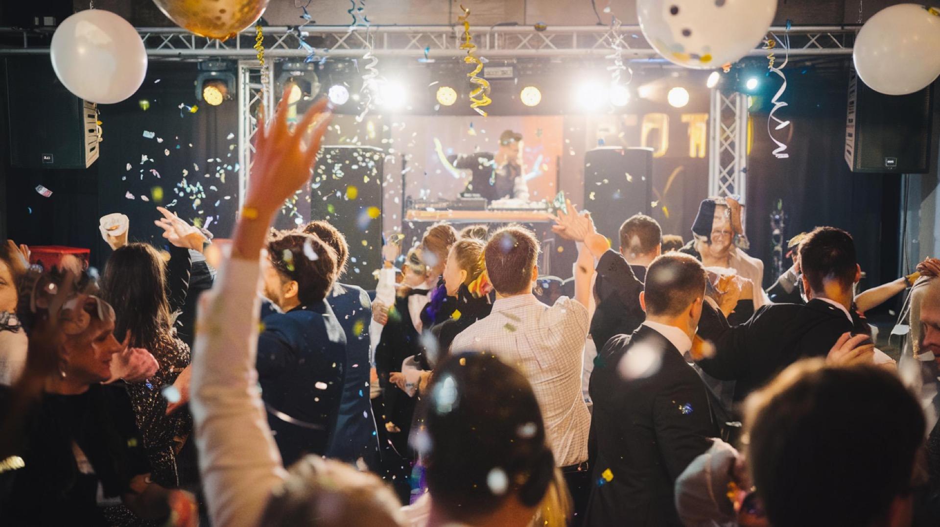Invitados bailando en un baby shower mixto con luces de colores en Bogotá — La Rumbería