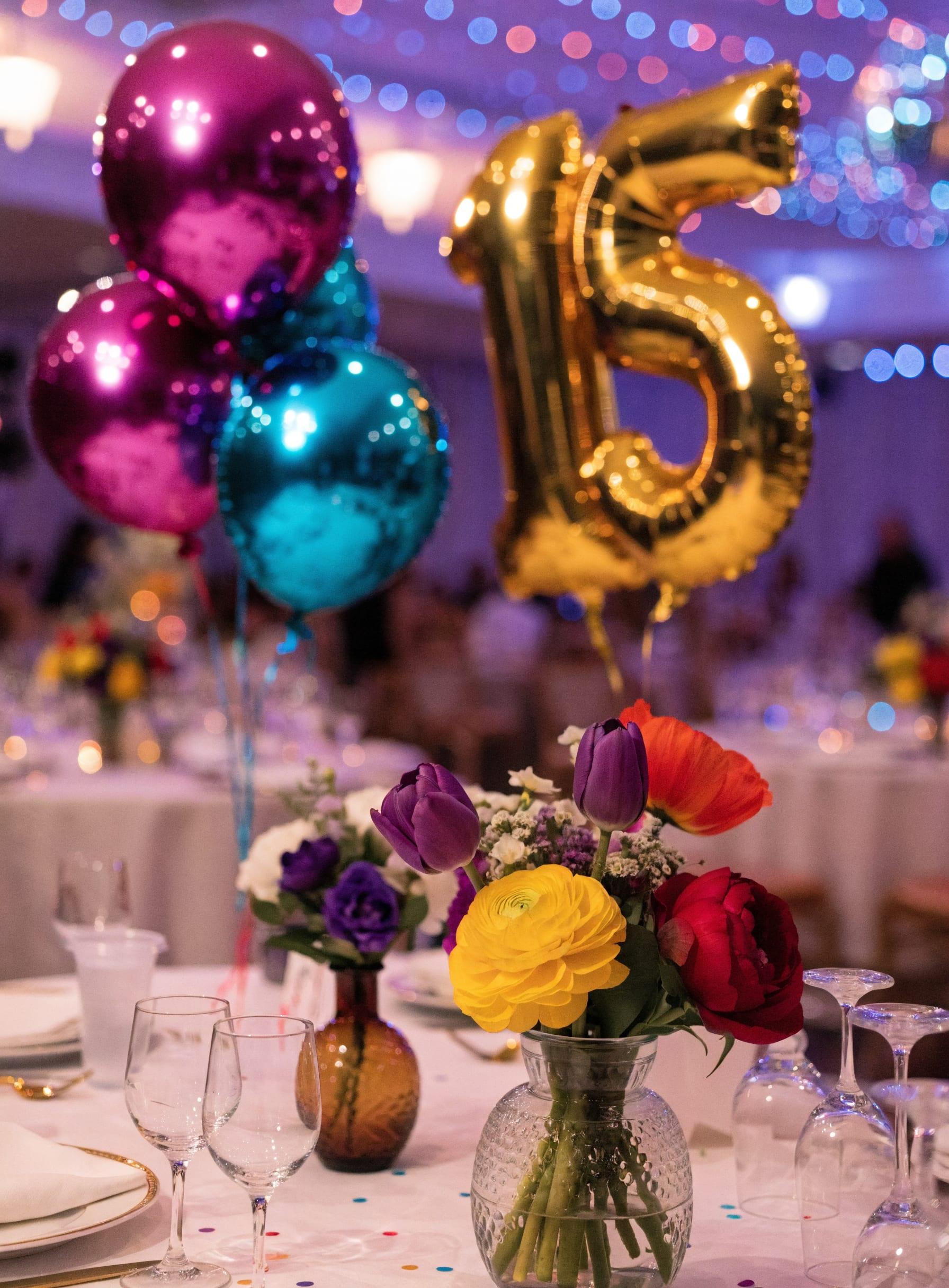 Decoración de quinceañera con globos magenta y turquesa, globo dorado de 15 y flores de colores en Bogotá — La Rumbería