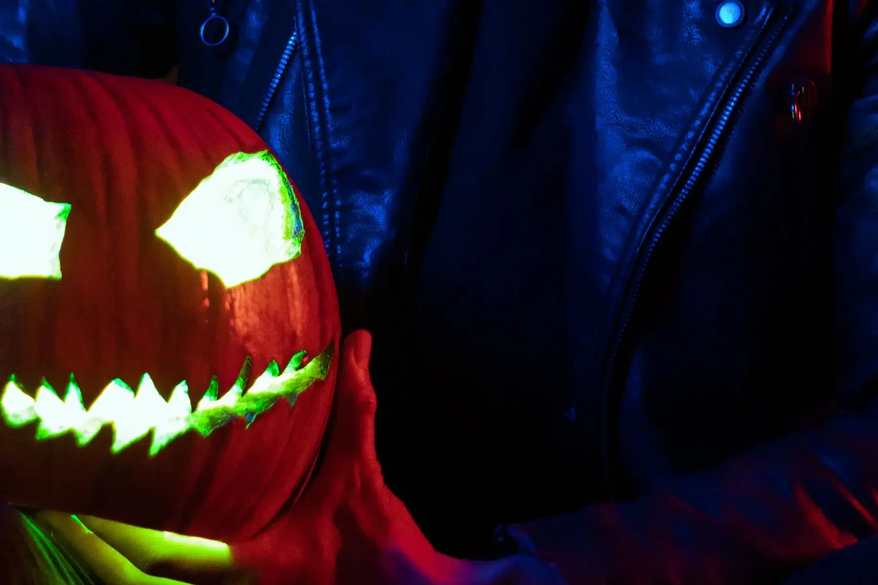 Fiesta de disfraces de Halloween en Bogotá: maquillaje de calavera y calabaza iluminada bajo luces neón — La Rumbería
