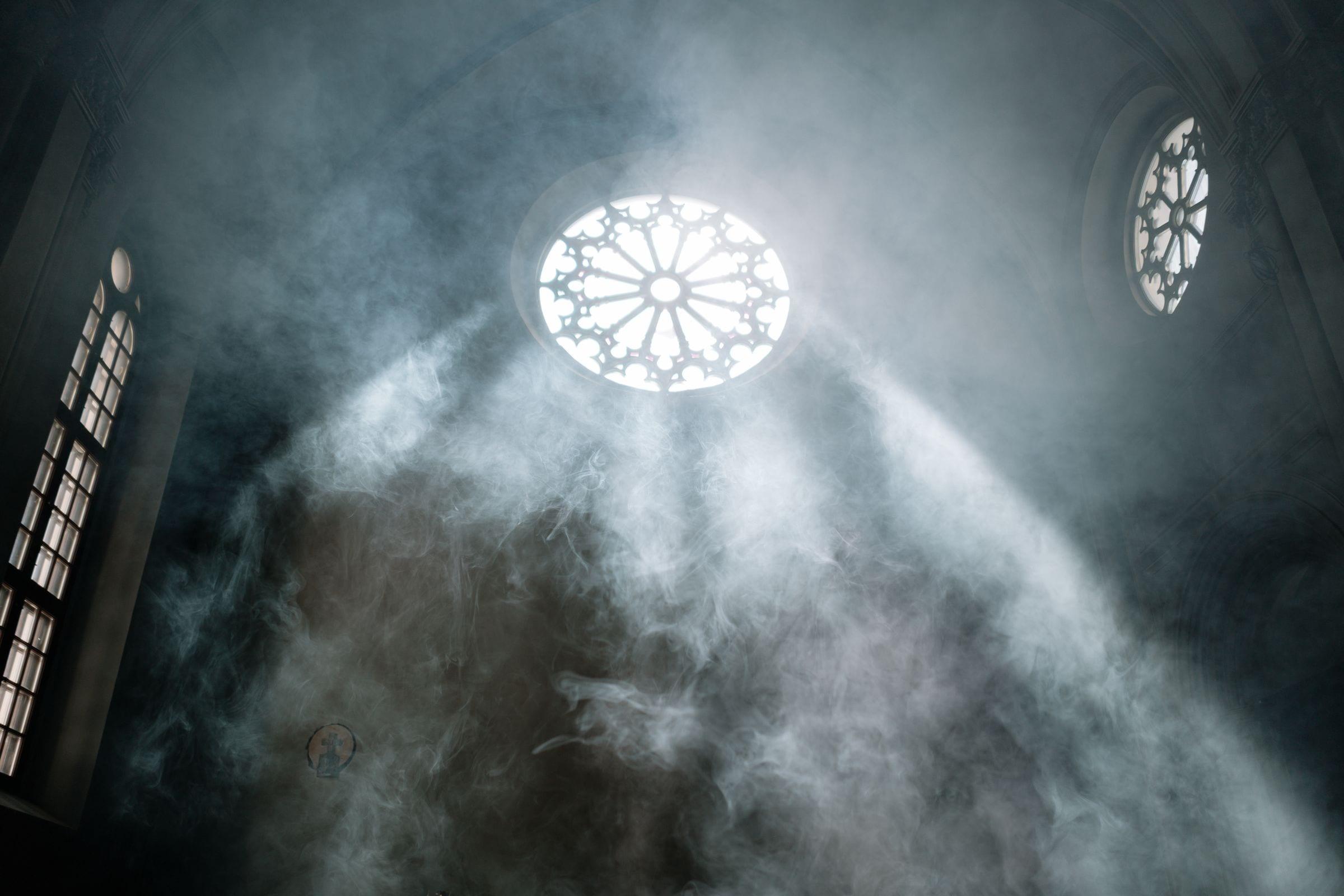 Humo iluminado por los vitrales de una iglesia antes de una ceremonia en Bogotá — La Rumbería