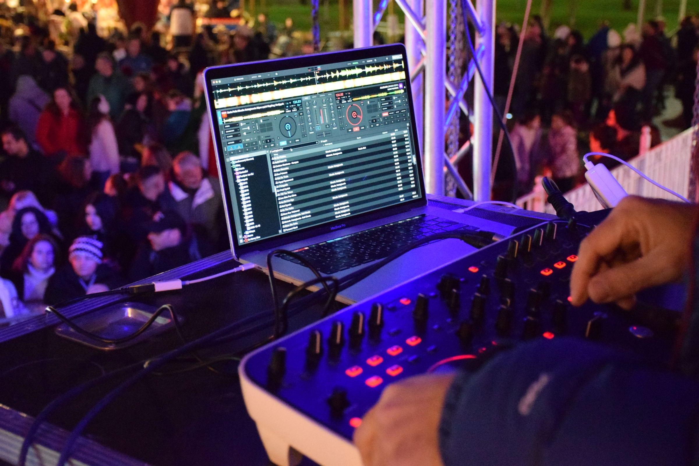 DJ operando en un evento de empresa de noche con público de pie en Bogotá — La Rumbería